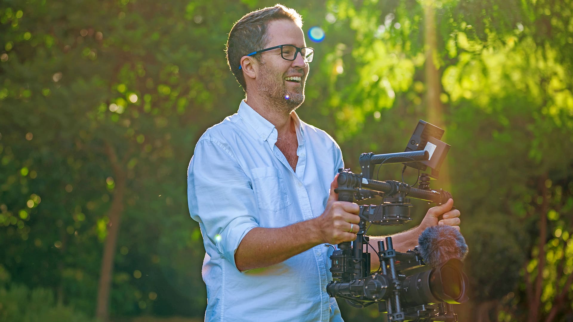 A professional videographer based in Adelaide smiling as he works with a gimbal